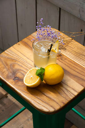 tasty cocktail with lemon ice and mint on a wooden backgroundの写真素材