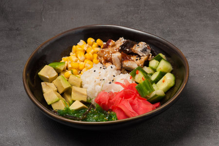 tasty poke with eel, avocado, cucumber, seaweed on a dark plateの写真素材