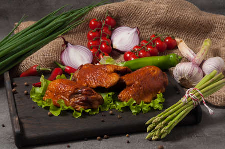 tasty smoked chicken thigh, garnished with fresh vegetablesの写真素材