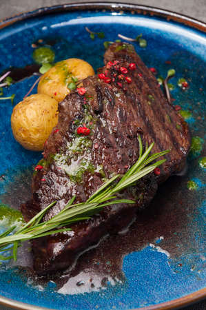 tasty marbled beef steak with new potatoes and green butterの写真素材
