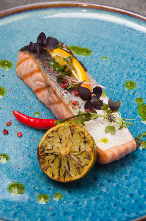tasty grilled salmon with skin with green oil and lemon