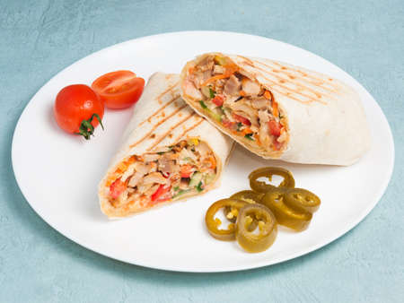 tasty shawarma with chicken and vegetables, jalapeno pepper on a blue backgroundの写真素材