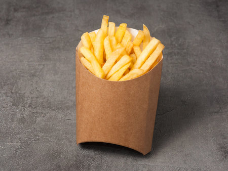 tasty french fries in brown craft packaging. close up