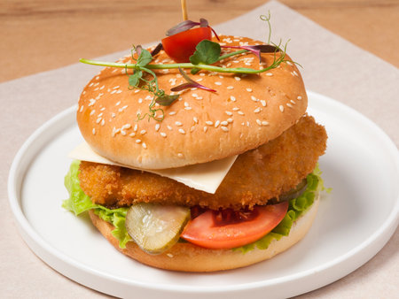 tasty burger with breaded chicken fillet cheese and vegetablesの写真素材