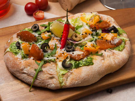 tasty italian pizza with smoked salmon, vegetables, mozzarella and parmesanの写真素材