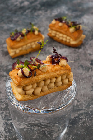tasty puff pastry appetizer with chicken pate and caramelized onions