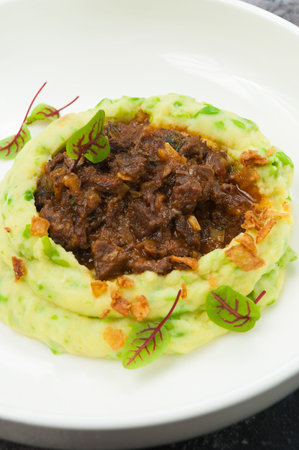 tasty beef stroganoff with mashed potatoes and green peasの写真素材