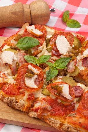 tasty pizza with pepperoni, bacon, chicken and mushroomsの写真素材