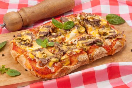 tasty pizza with beef gherkins and jalapeno, mozzarella cheese and cheddar sauceの写真素材