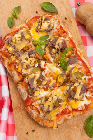 tasty pizza with beef gherkins and jalapeno, mozzarella cheese and cheddar sauceの写真素材