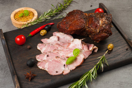 tasty boiled and smoked pork delicacies on a dark wooden boardの写真素材