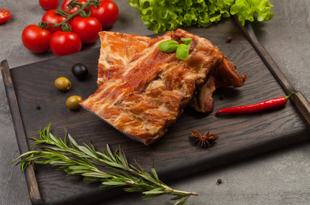 tasty pork ribs boiled and smoked on a dark wooden boardの写真素材