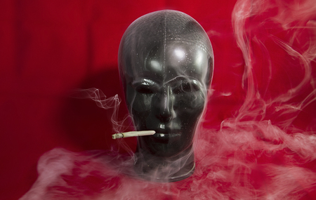 Black decoration head with cigarette and smokeの写真素材