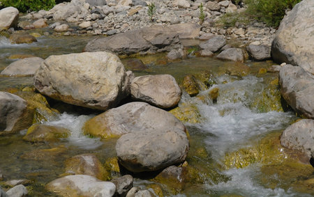 Rocks on riverbank with river in background 