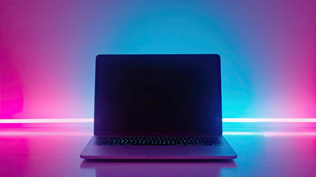 Laptop with black screen on purple and blue background with neon lights.の素材