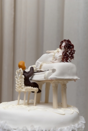 figurines of the bride and groom on a wedding cakeの写真素材