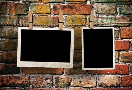 pictures on a rope with clothespins, with clipping path for images, in front of a brick wallの写真素材