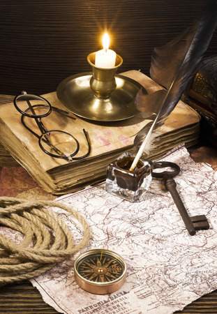 ancient books with candle and Compass on the old paper backgroundの写真素材