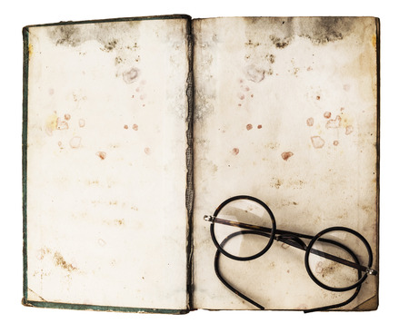 Old books with eye glasses isolated on white backgroundの写真素材