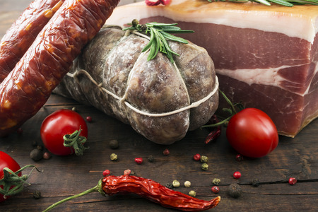 delicacy smoked sausage (salami) on a wooden boardの写真素材