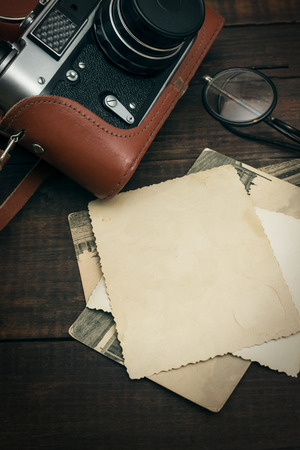 retro still camera and some old photos on wooden table backgroundの写真素材