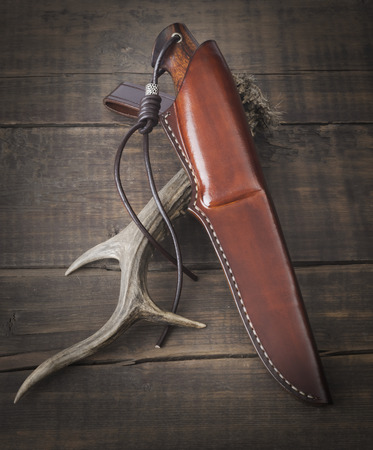 hunting knife handmade on a brown wooden backgroundの写真素材