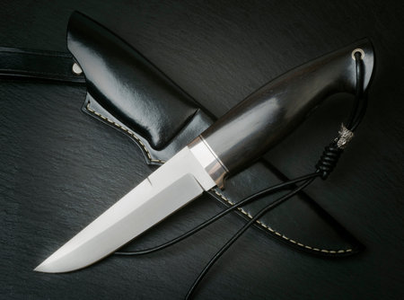 hunting knife handmade on a brown wooden background