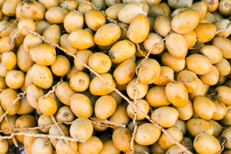 Freshly harvested branches with dates (Phoenix dactylifera) Date palm on a traditional craftsman...