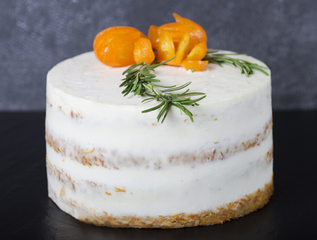 Carrot cake decorated with a branch of rosemary and kumquat on a dark background. Selective focusの写真素材