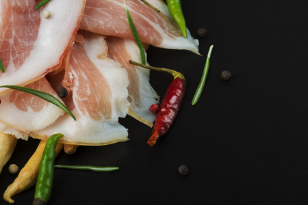 Grissini bread sticks with prosciutto on a black  with rosemaryの写真素材