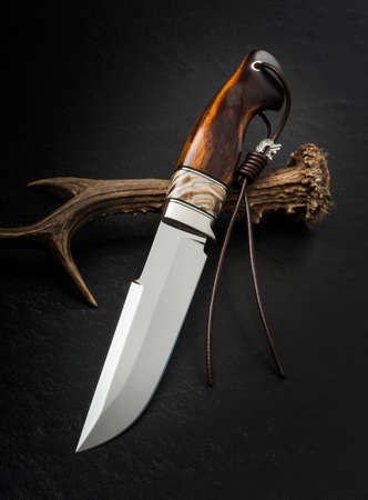 Hunting knife handmade on a black background.の写真素材