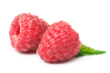 Ripe red raspberry with green leaf isolated on white background