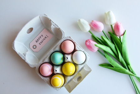 A bouquet of tulips with Easter eggs on a white backgroundの写真素材