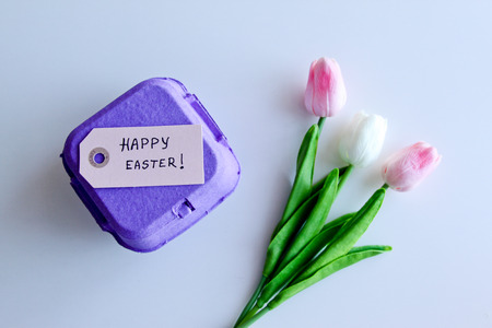 A bouquet of tulips with Easter eggs on a white backgroundの写真素材