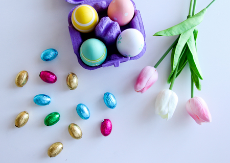 A bouquet of tulips with Easter eggs on a white backgroundの写真素材