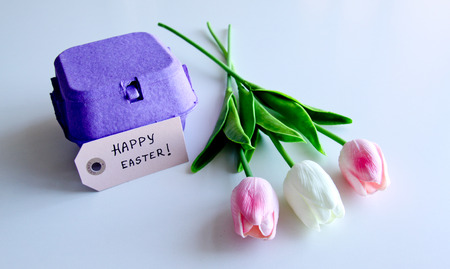 A bouquet of tulips with Easter eggs box on a white backgroundの写真素材