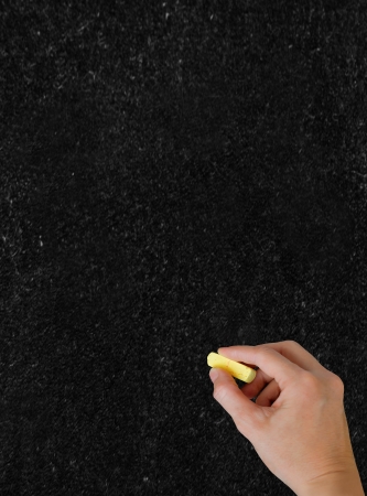 Blackboard. The hand writing with chalk.  Vertical shot.の写真素材