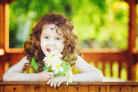 Laughing girl with a flower in her hand. Toning photo.の写真素材