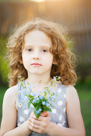 Little girl with a flower in her hand. Mothers day concept.の写真素材