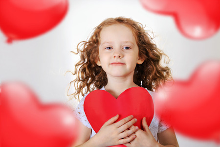 Sweet girl holding red paper heart. Valentines day or healthcare, medical concept.の写真素材