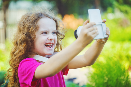 Laughing girl taking selfie with photo camera.の写真素材