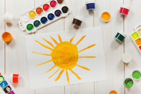 Drawing sun on the desktop, a top view. Education and art, creative concept.の写真素材