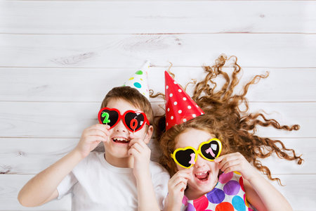 New Years 2017, christmas holiday. Funny children with sunglasses heart shape, hold 2017 candles,...