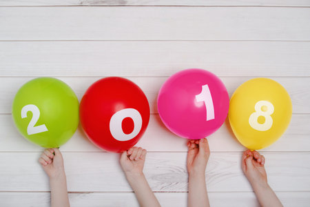 Child hand holding rainbow balloons with 2018. Happy New Year or christmas concept.の写真素材