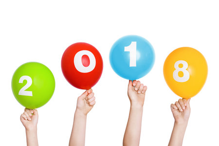 Happy New Year child hand holding rainbow balloons with 2018, isolated in white.