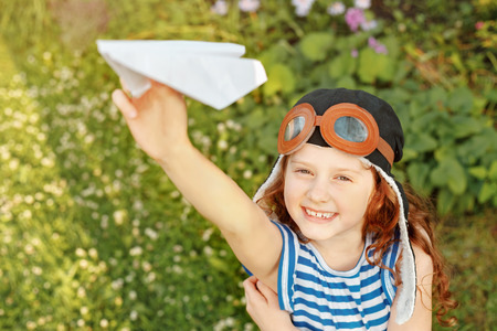 Laughing girl playing with paper airplane. Vacation, freedom concept.の写真素材