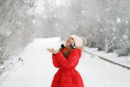 Funny girl stuck out her tongue and catches snowflakes. Happy childhood, Christmas concept.の写真素材