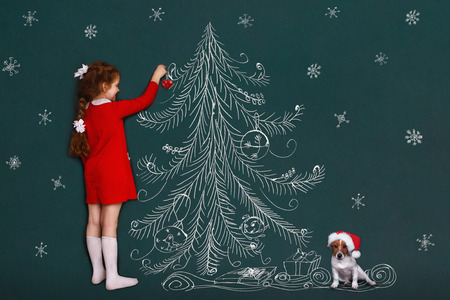 Cute girl and her jack russell dog with decorates a Christmas tree. 2018 holiday concept.の写真素材
