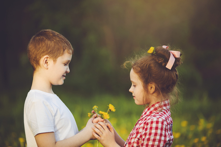 Little Boy gift flowers his friend girl. Valentines day concept.の写真素材