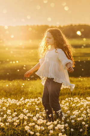 Cute curly baby dreaming or relaxing on meadow outdoors. Healthy, lifestyle, happy childhood concept.の写真素材